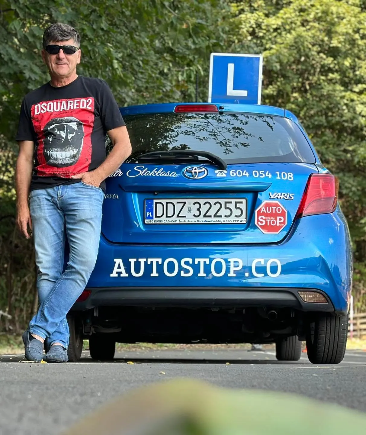 Piotr Stokłosa przy szkolnej Toyocie Yaris w barwach Auto-Stop, z tablicą L